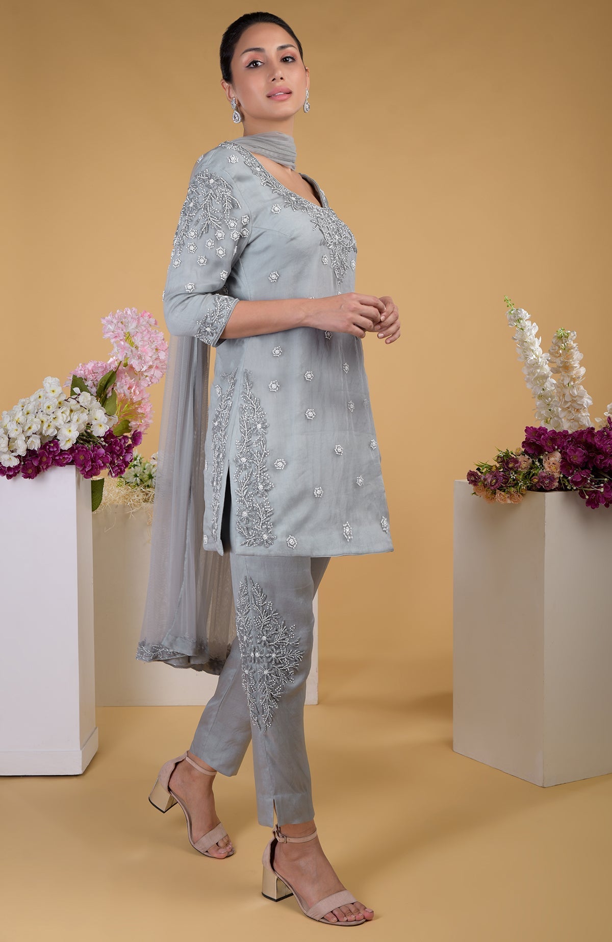 A woman models a grey silk organza hand-embroidered kurta set with pearl embellishments.