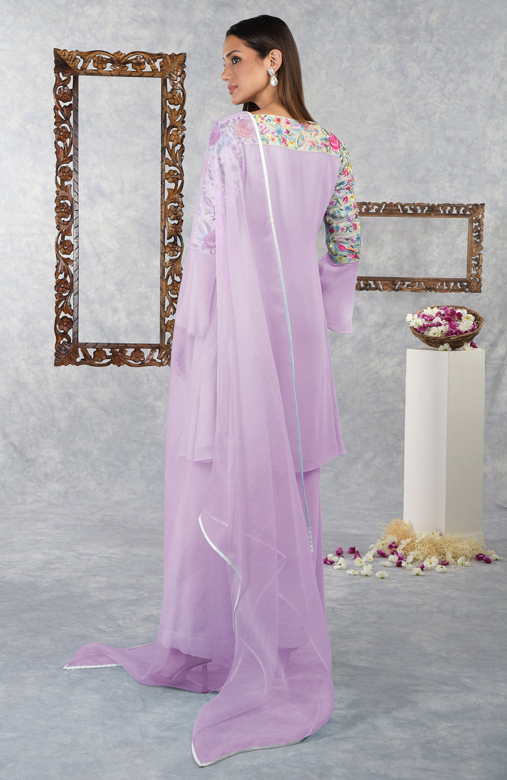 Woman in a lilac Parsi Gara embroidered kurta set with a flowing dupatta.
