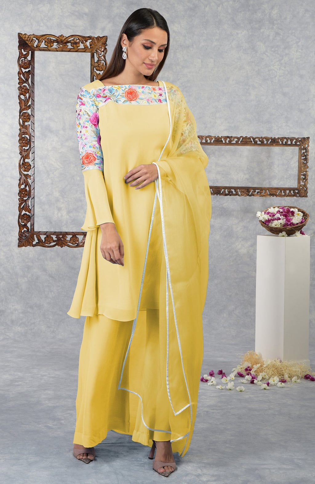A woman models a yellow Parsi Gara embroidered kurta set with bell sleeves.
