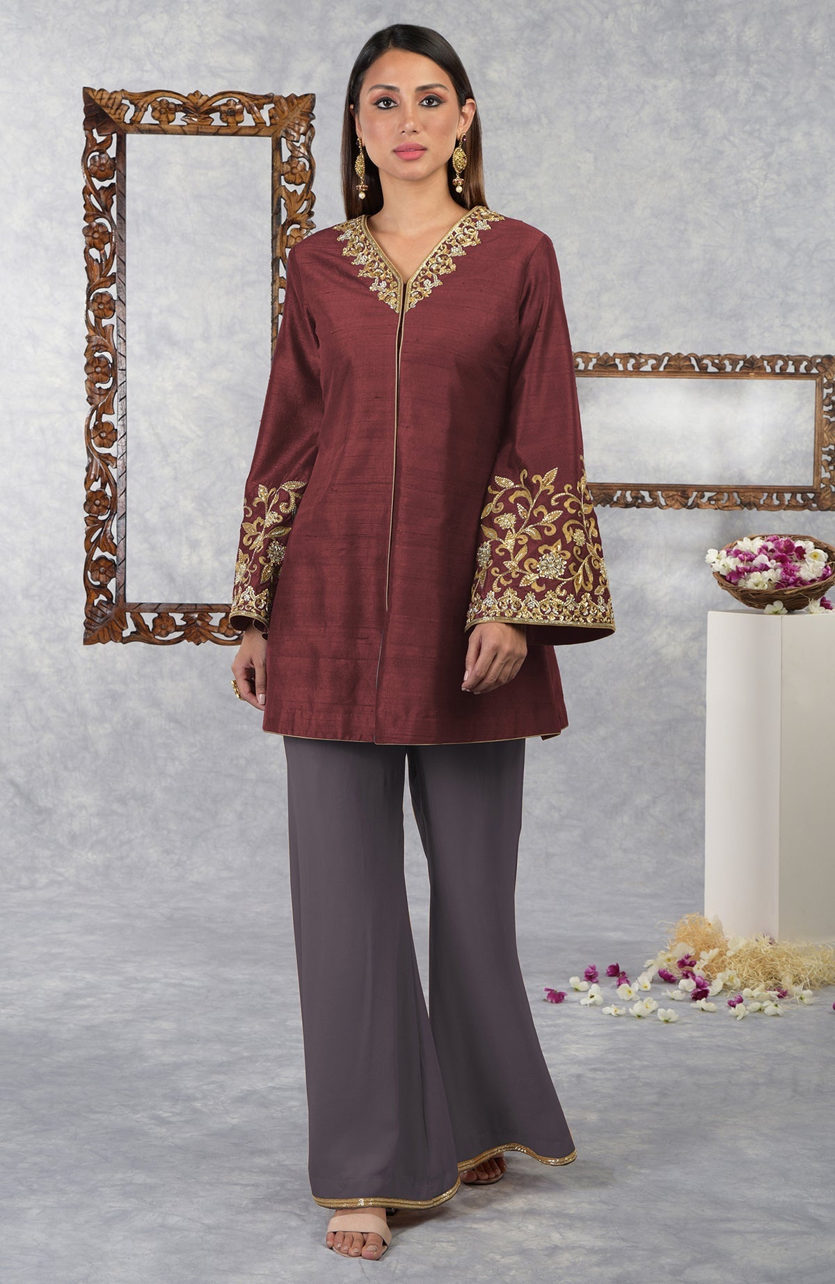 A woman models a pomegranate-mulled grape raw silk hand-embroidered jacket set.