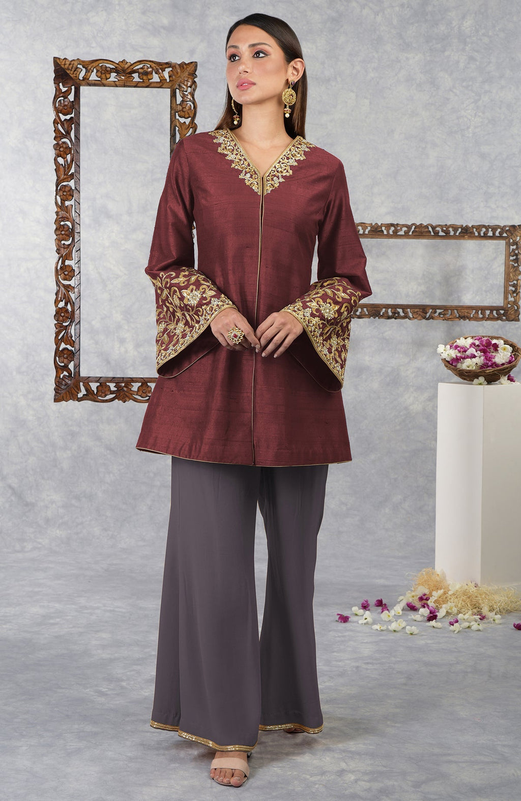 A woman models a pomegranate-mulled grape raw silk hand-embroidered jacket set.