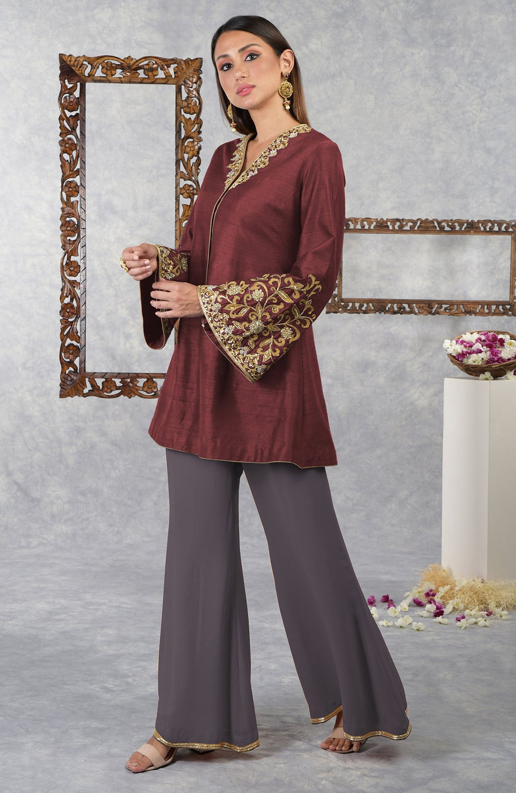 A woman models a pomegranate-mulled grape raw silk jacket set with hand embroidery.