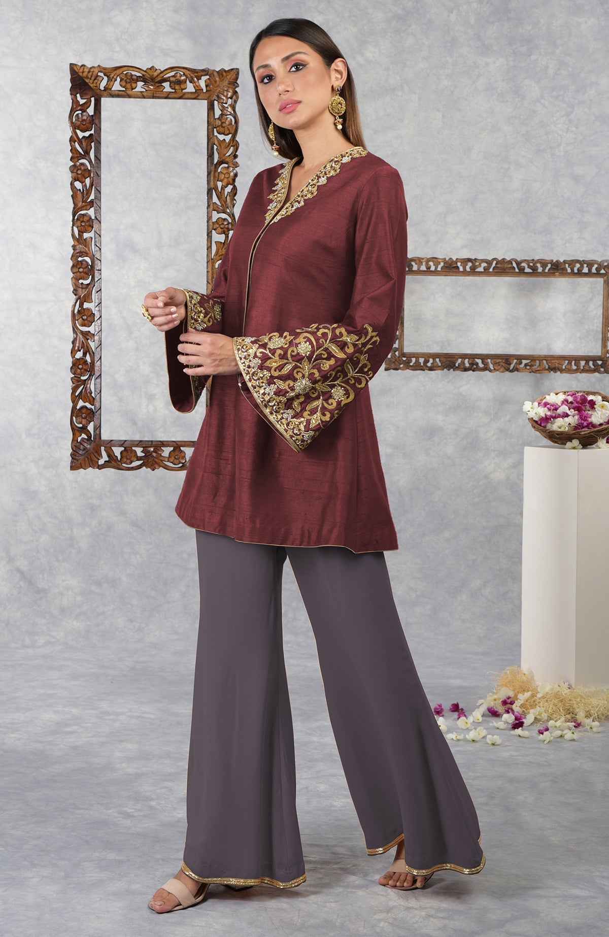 A woman models a pomegranate-mulled grape raw silk jacket set with hand embroidery.