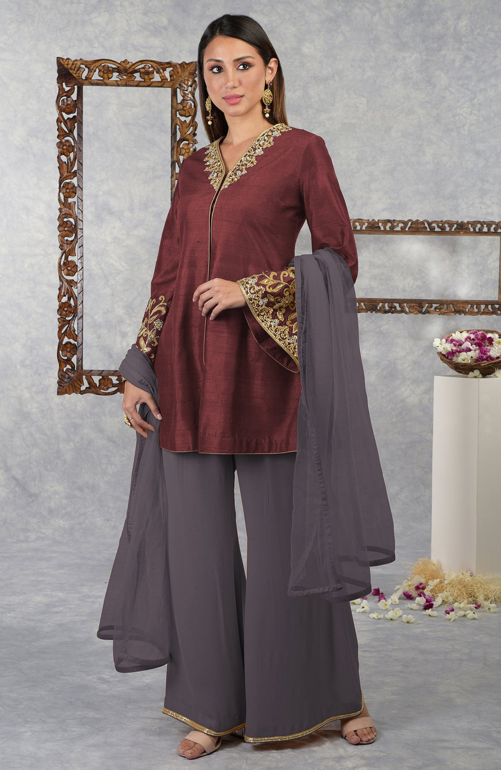 A woman models a pomegranate-mulled grape raw silk jacket set with a dupatta.
