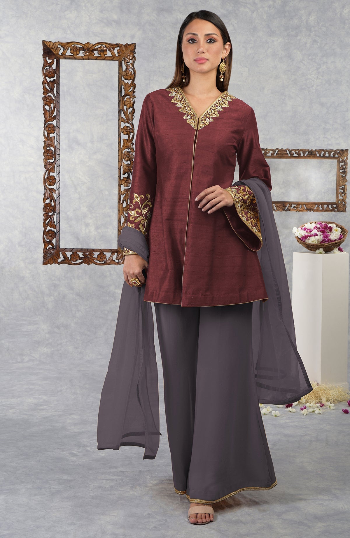 A woman models a maroon raw silk jacket set with a gray dupatta.