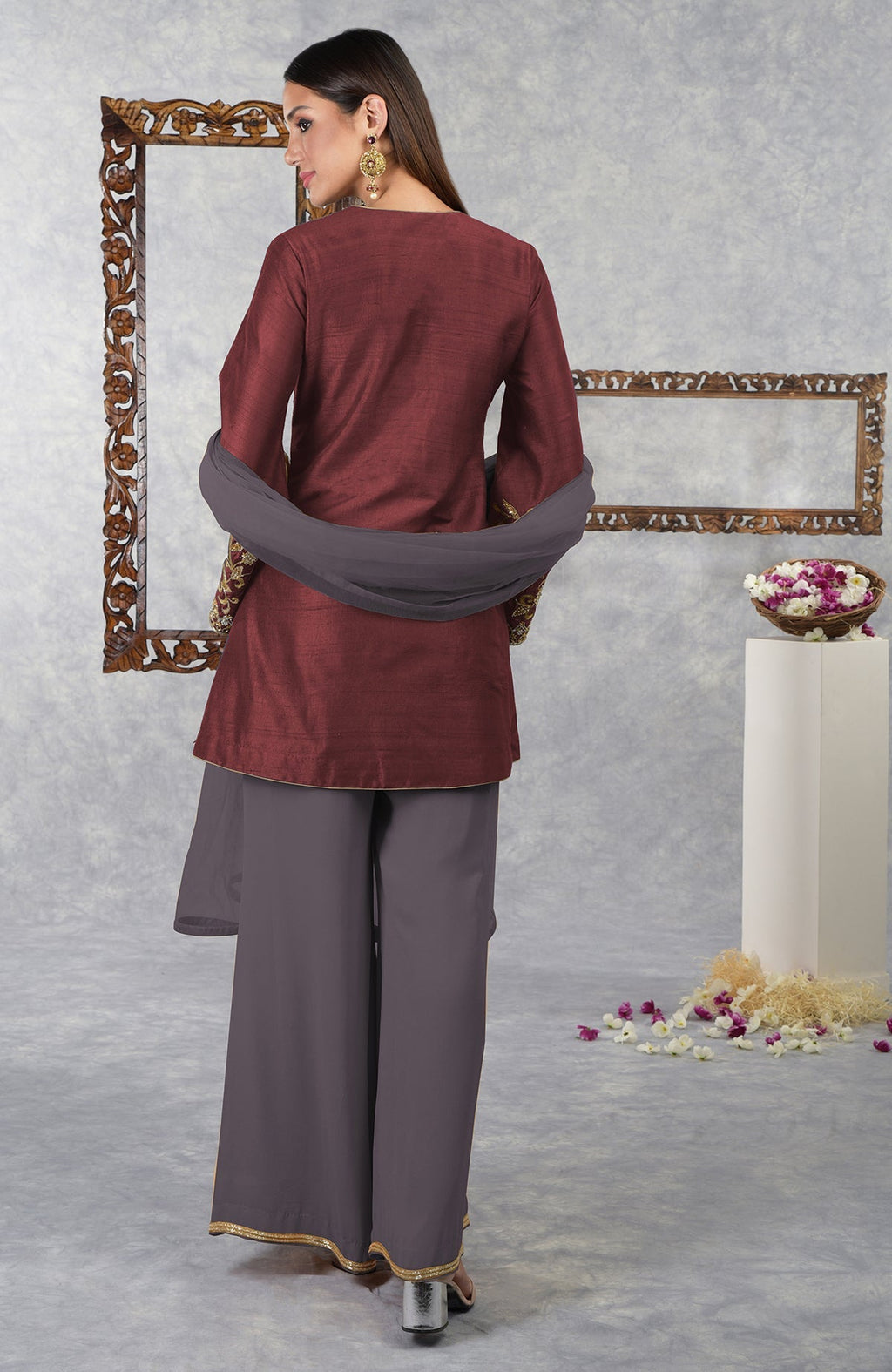 A woman models a pomegranate-mulled grape raw silk hand-embroidered jacket set with dupatta.