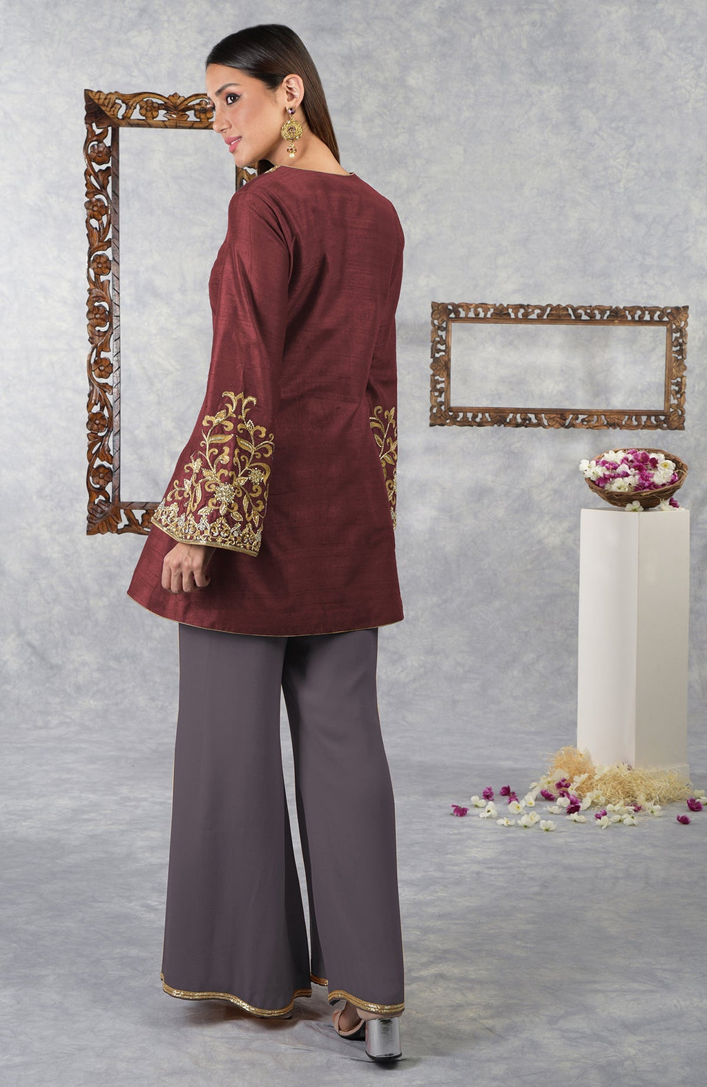 A woman models a pomegranate-mulled grape raw silk hand-embroidered jacket set.