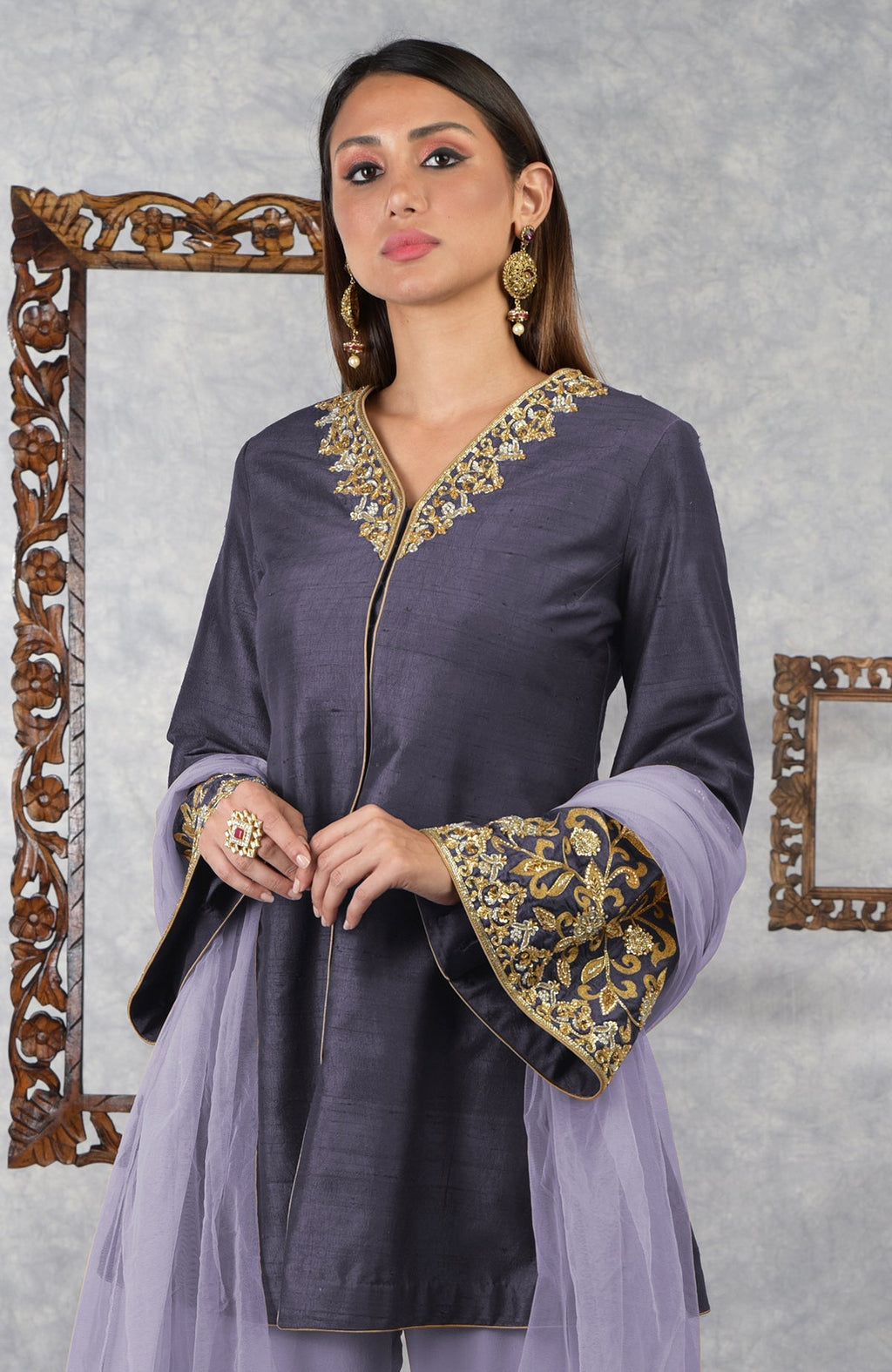 A woman models a smoky violet raw silk jacket set with pastel lilac dupatta.