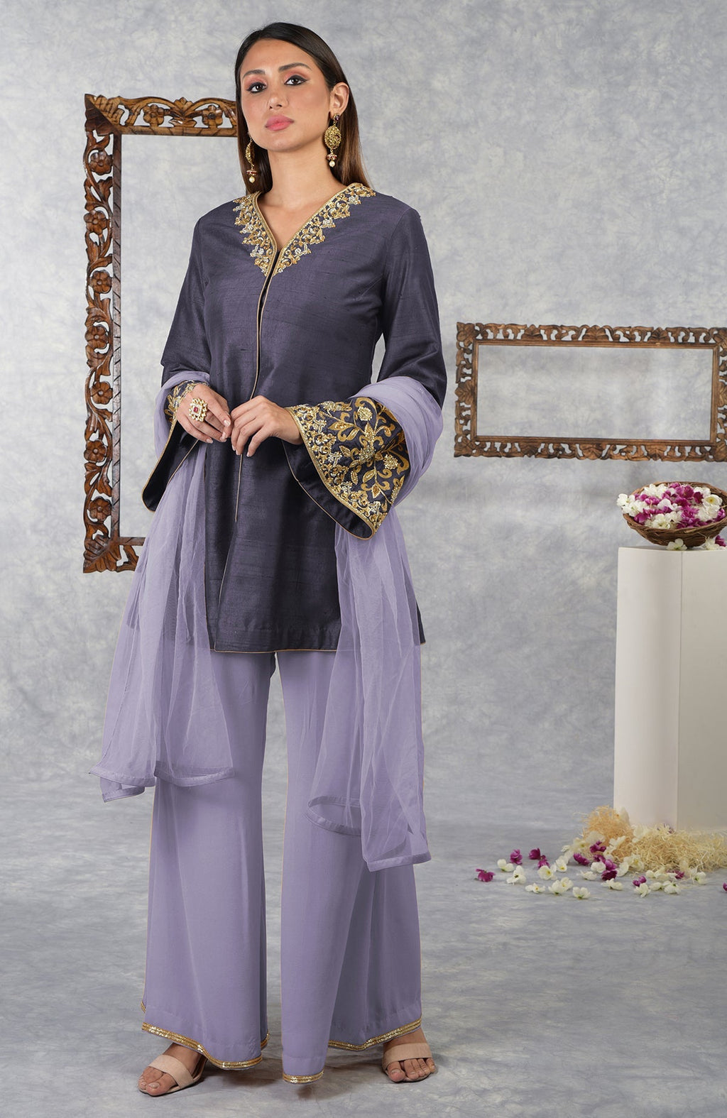 A woman models a smoky violet raw silk hand-embroidered jacket set with a pastel lilac dupatta.