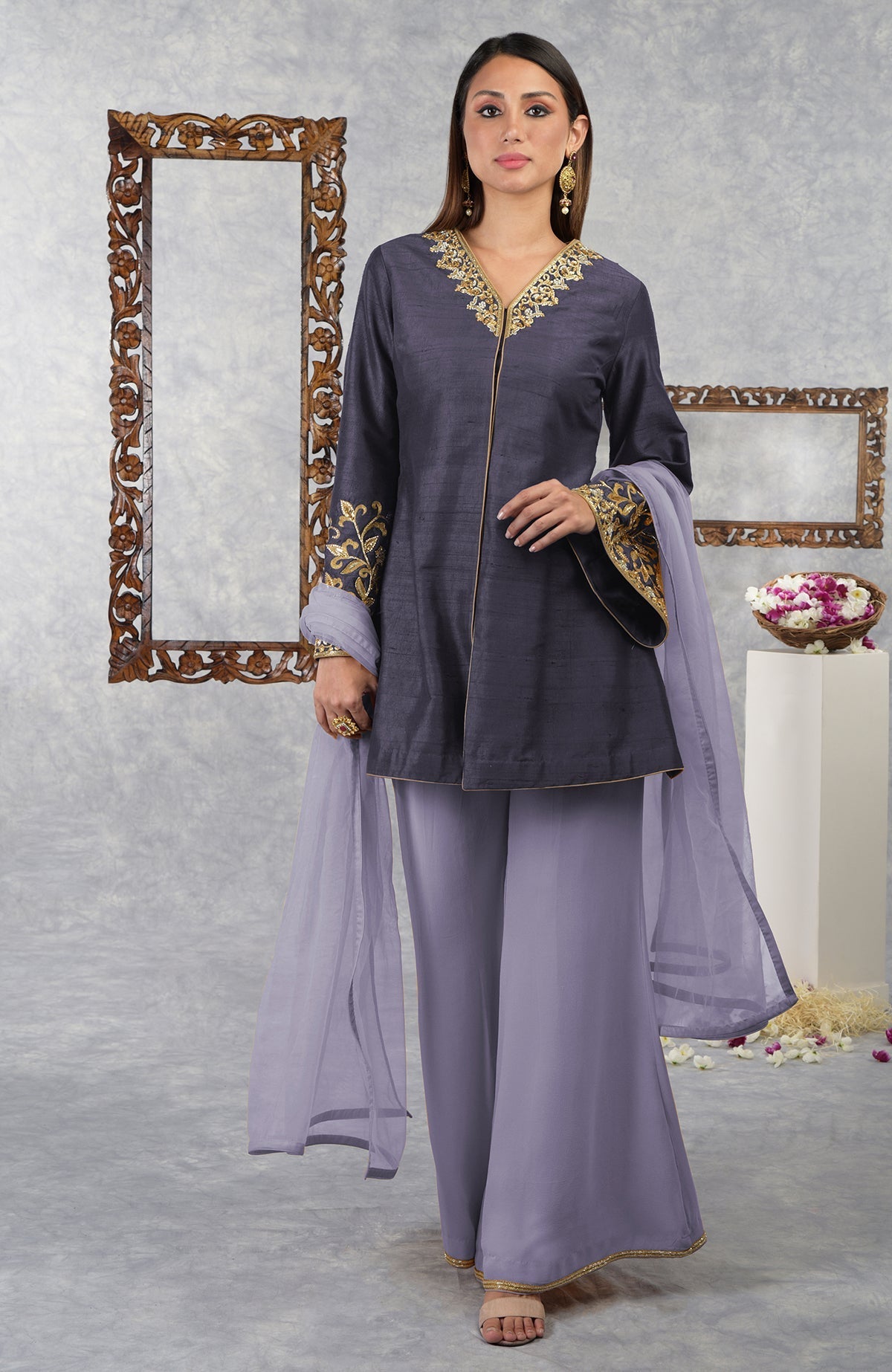 A woman models a pomegranate-mulled grape raw silk jacket set with dupatta.