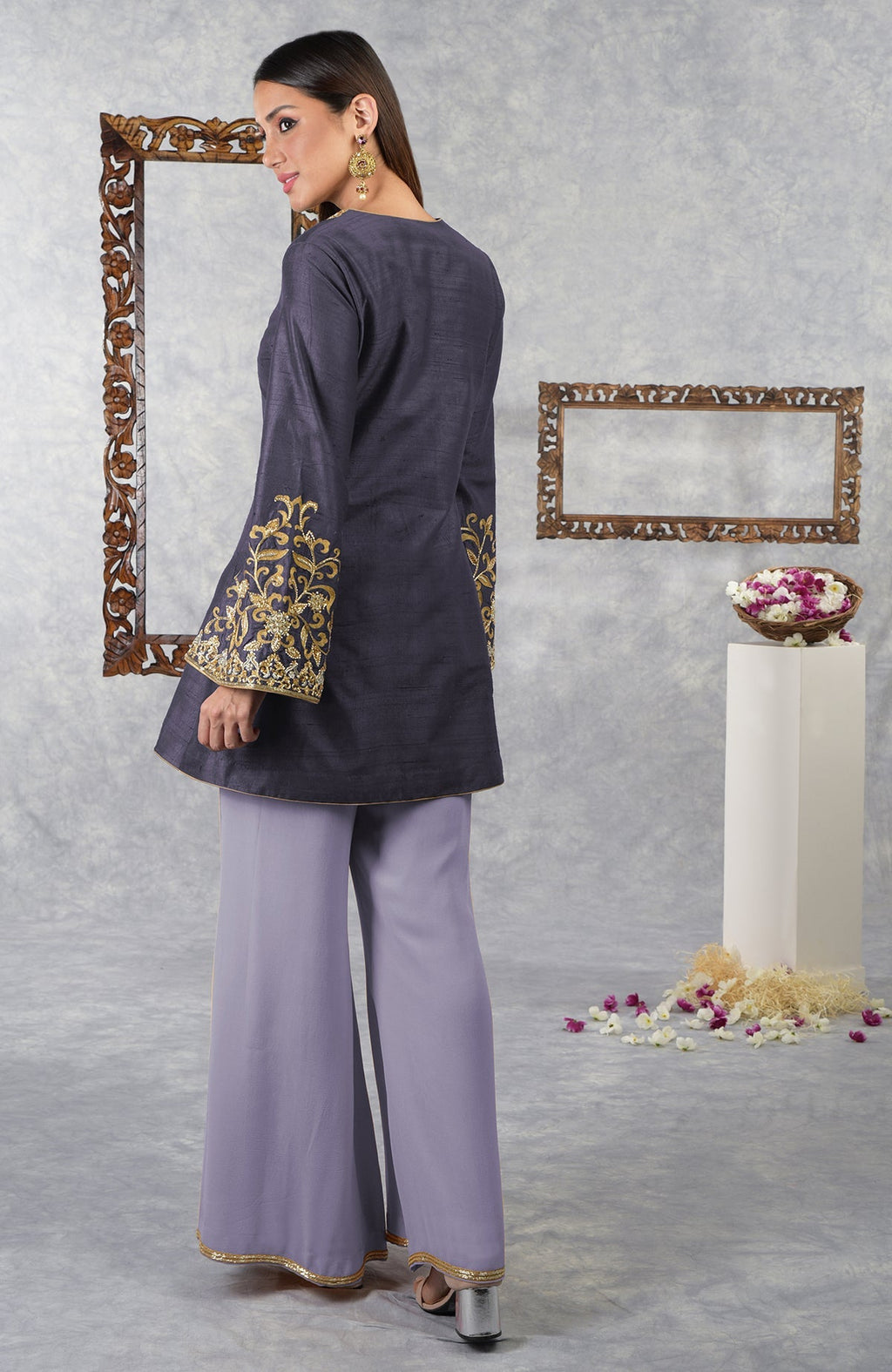 A model wears a smoky violet raw silk hand-embroidered jacket set with pastel lilac palazzo pants.