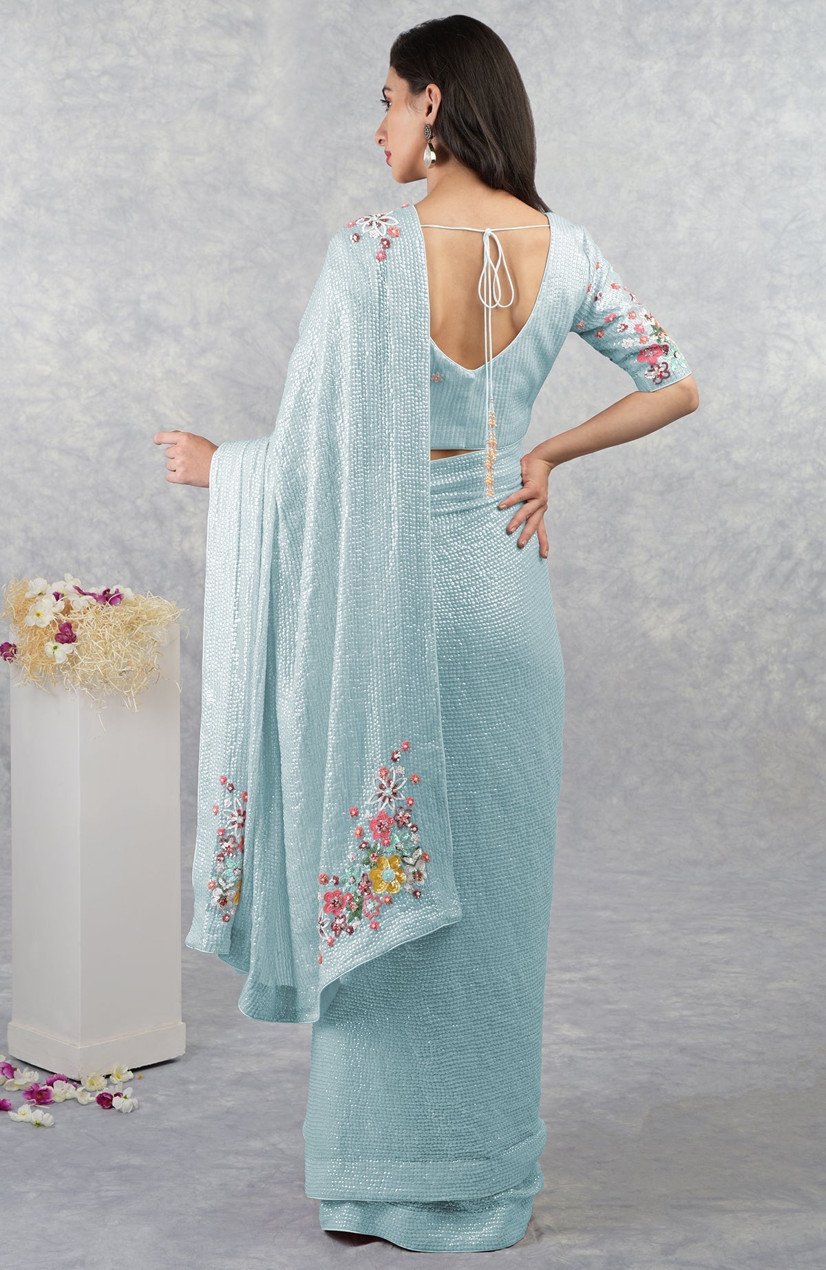Aqua blue floral sequin saree with a matching blouse, worn by a model.