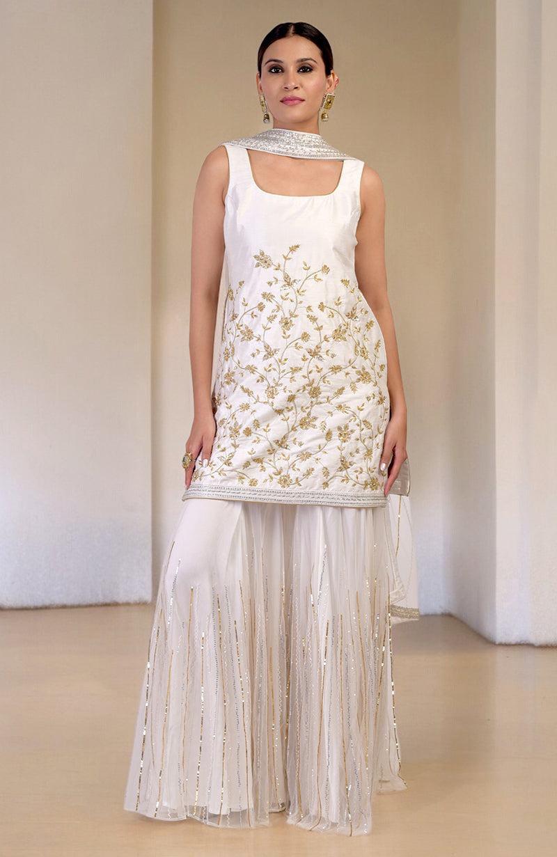 A woman models a white and gold hand-embroidered sharara set.