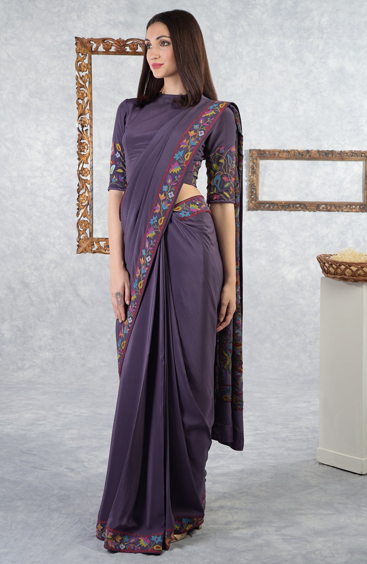 An eclipse-colored saree with Kani art embroidered floral motifs and a matching blouse.