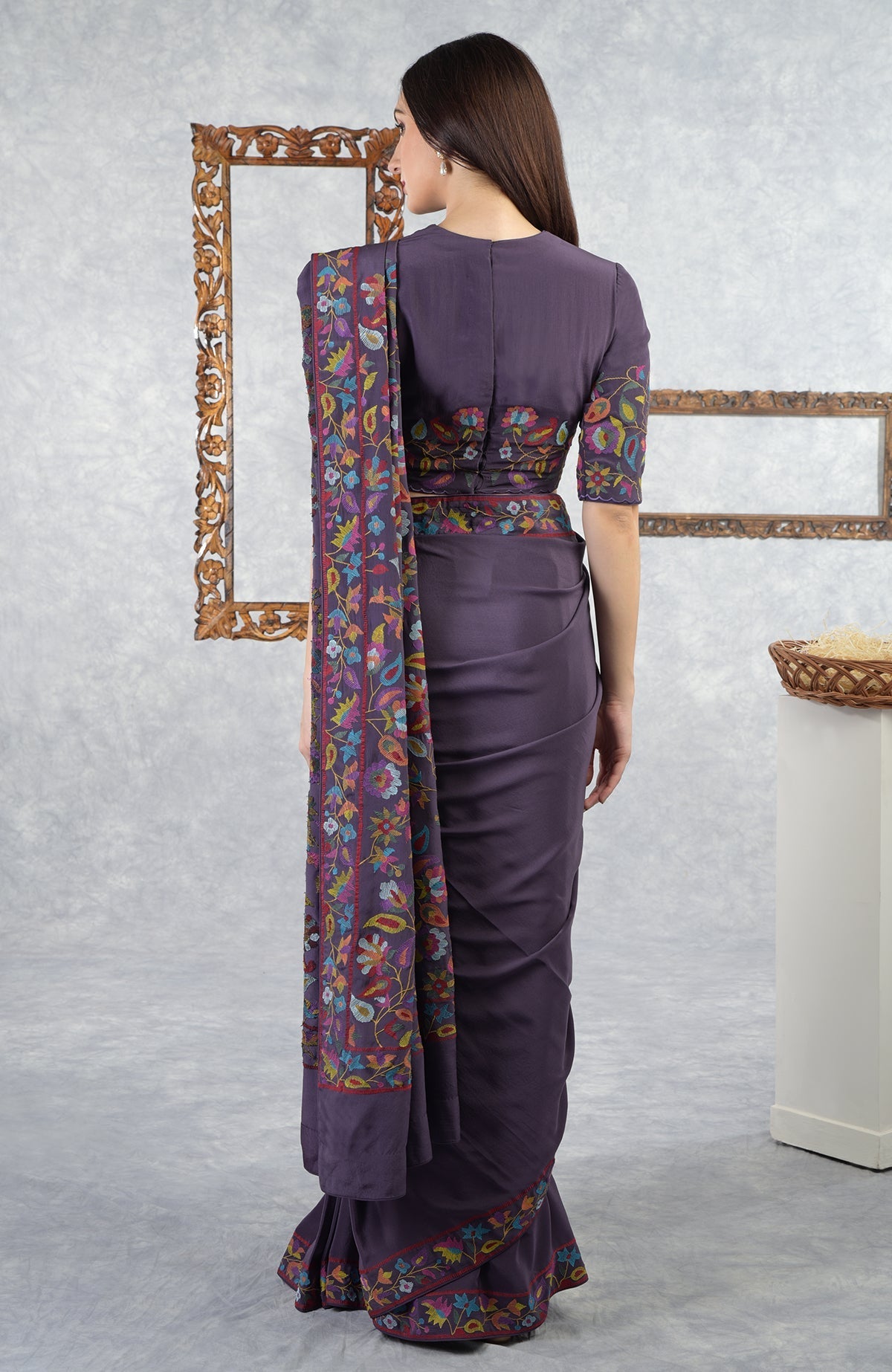 Woman in an eclipse-colored saree with multi-color floral Kani art embroidery.