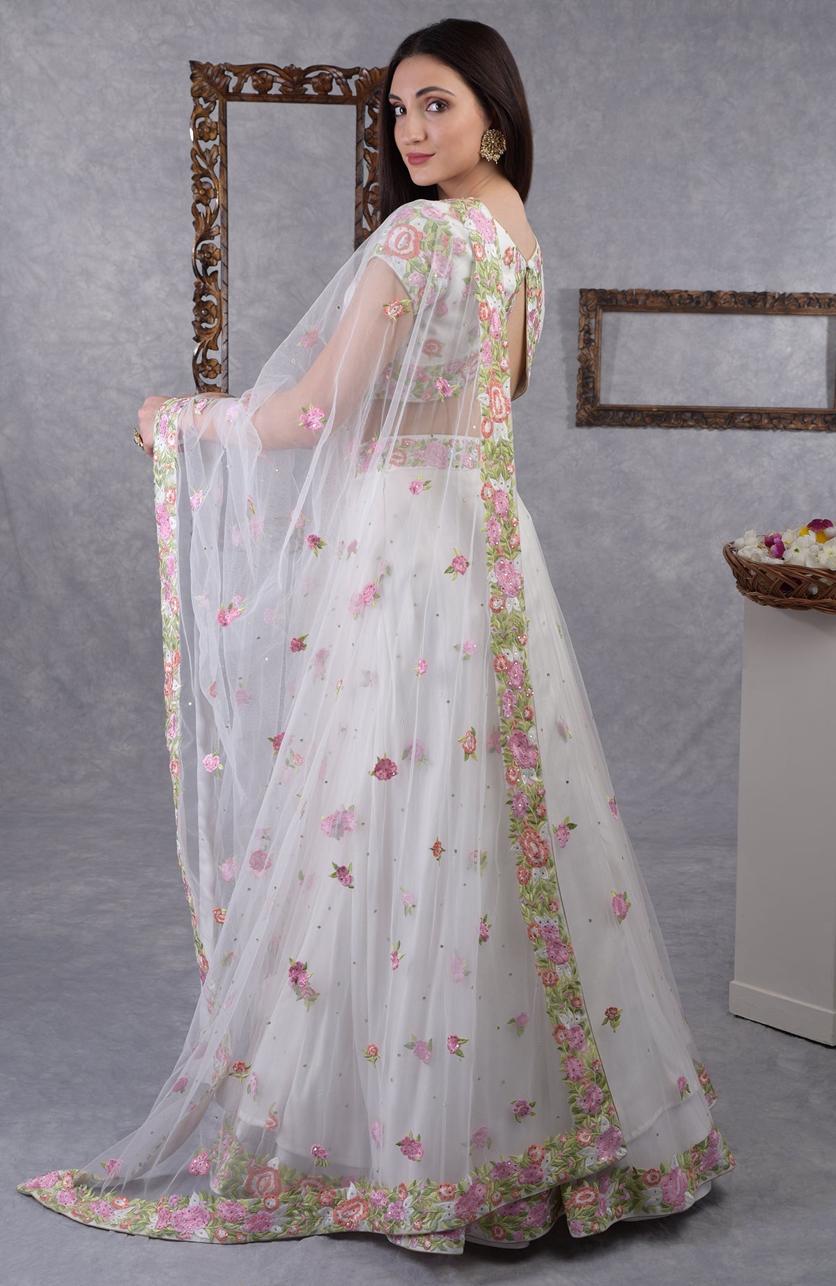Pearl white lehenga set with pastel floral resham embroidery and sequin on blouse, skirt, and dupatta.