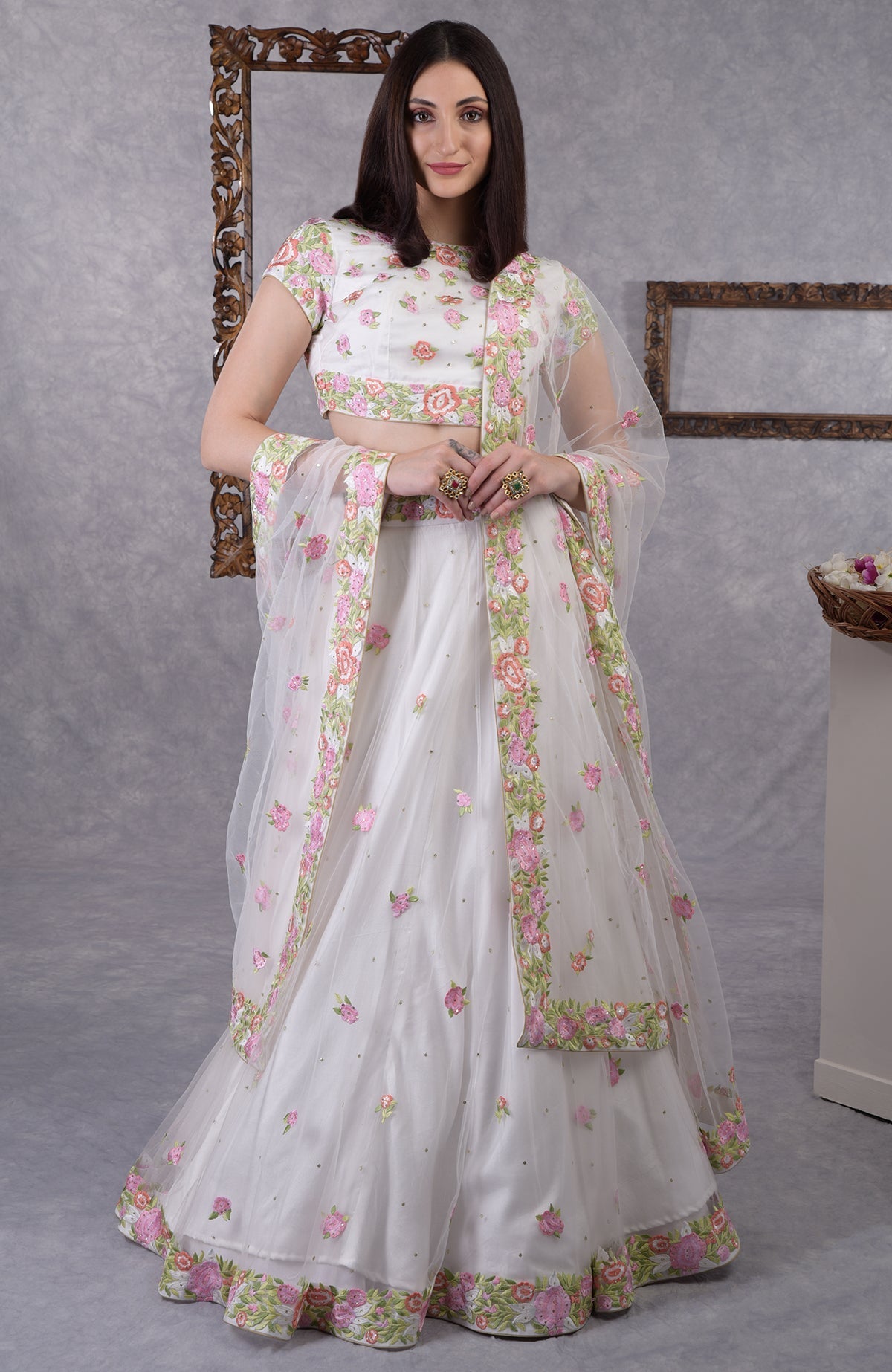 Pearl white lehenga set with pastel floral resham embroidery and sequin on blouse, skirt, and dupatta.