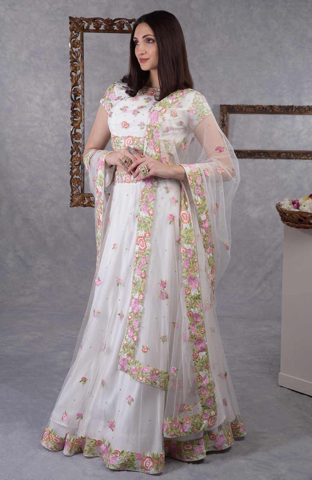 Pearl white lehenga set with pastel floral resham embroidery and sequin on blouse, skirt, and dupatta.