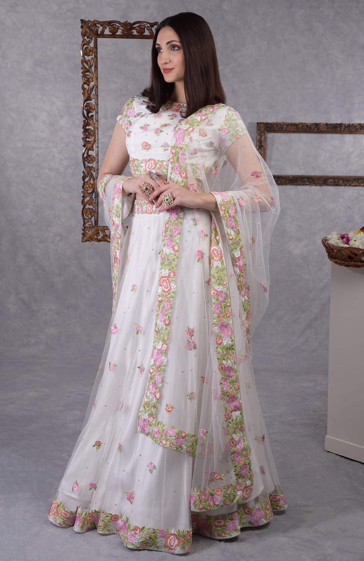 Pearl white lehenga set with pastel floral resham embroidery and sequin on blouse, skirt, and dupatta.