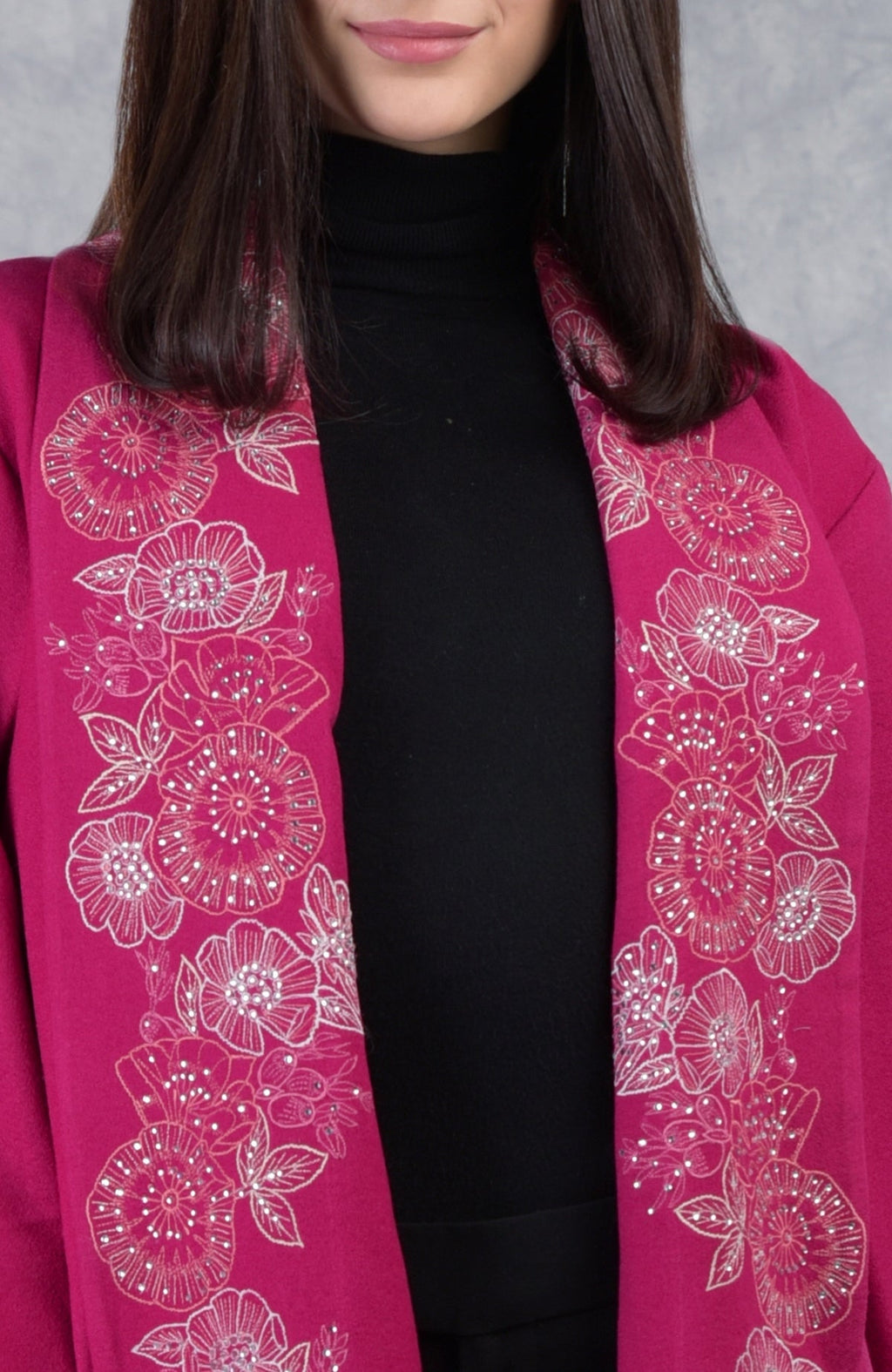A woman wears a fuchsia rose floral embroidered pure wool crepe jacket over a black top.
