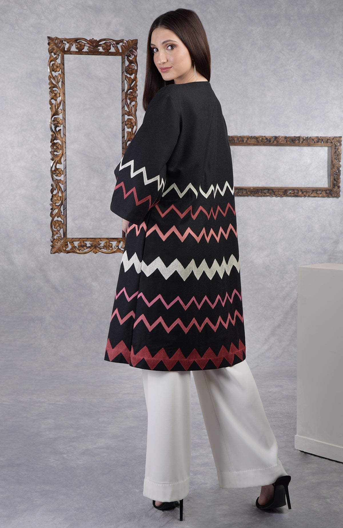 Black wool crepe jacket with chevron embroidery, 3/4 bell sleeves, and side pockets.