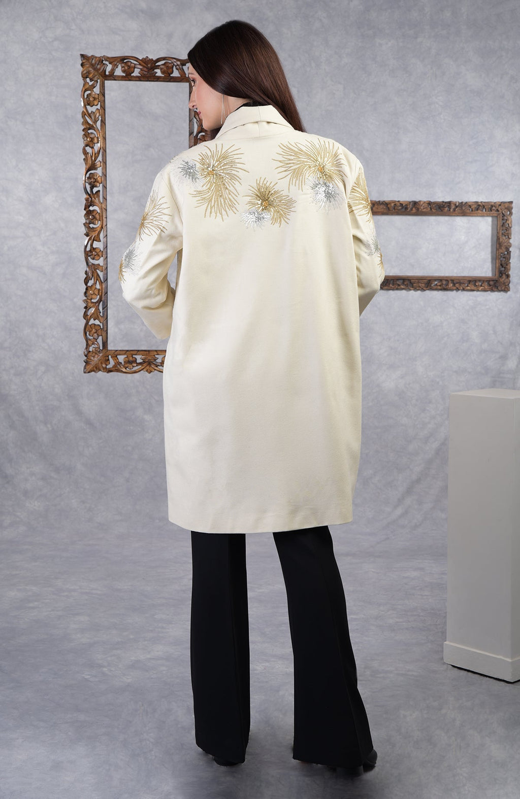 Ivory wool crepe jacket with starburst embroidery, shawl collar, drop shoulders, and pockets.