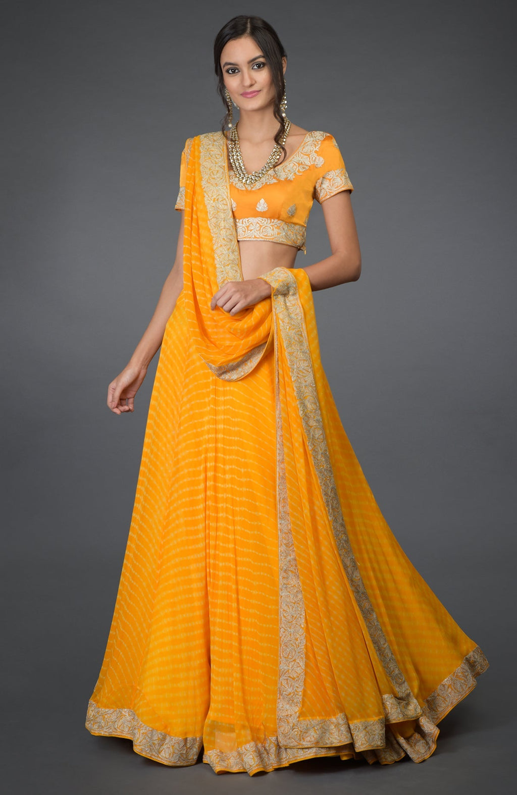 Yellow chiffon lehenga set with silver tilla embroidery and satin silk blouse with cap sleeves.