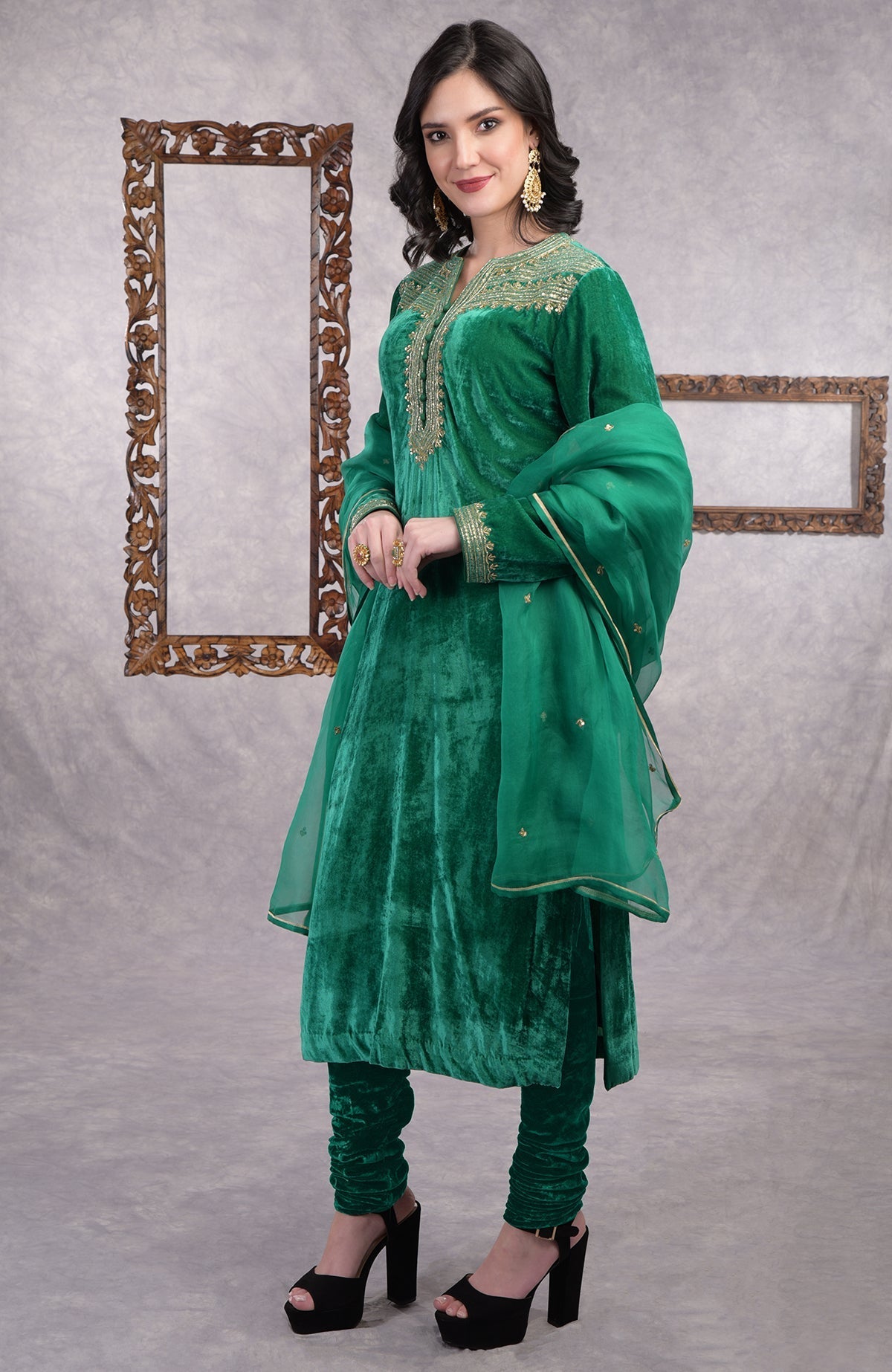 Rich green velvet kurta set with gold zardozi embroidery and matching churidar and dupatta.
