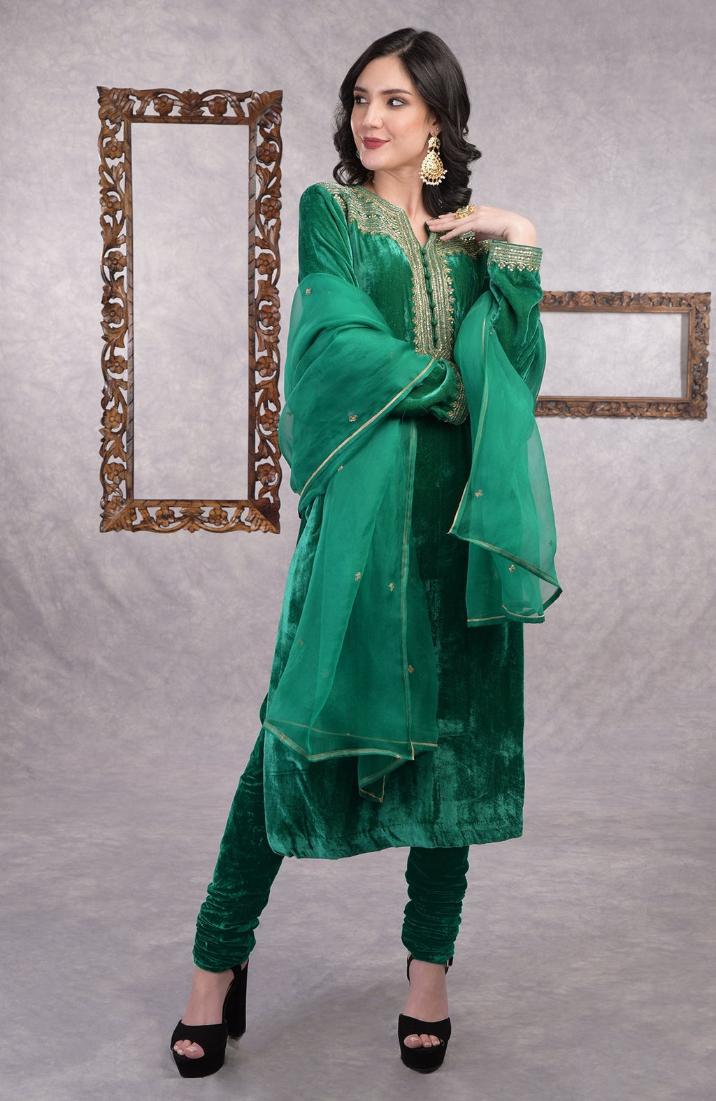 Rich green velvet kurta set with gold zardozi embroidery and matching churidar and dupatta.
