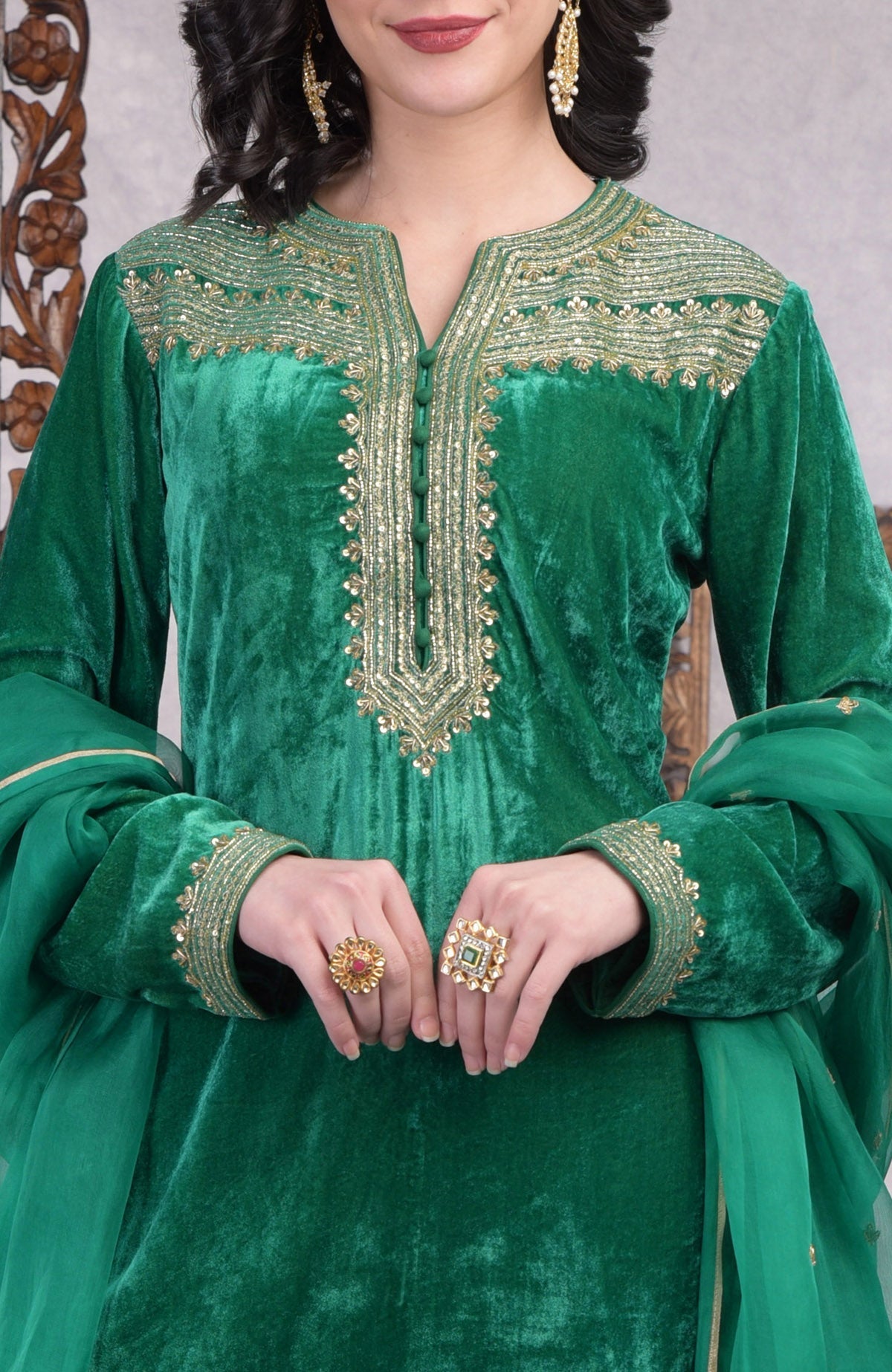Rich green velvet kurta set with gold zardozi embroidery and matching churidar and dupatta.