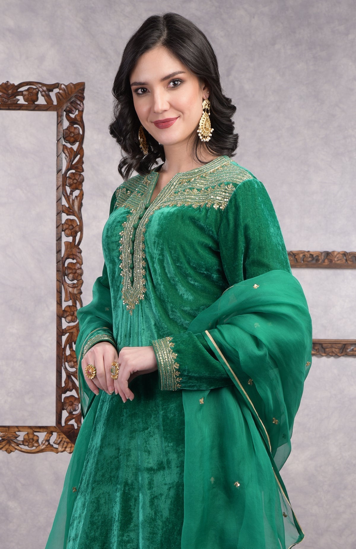 Rich green velvet kurta set with gold zardozi embroidery and matching churidar and dupatta.
