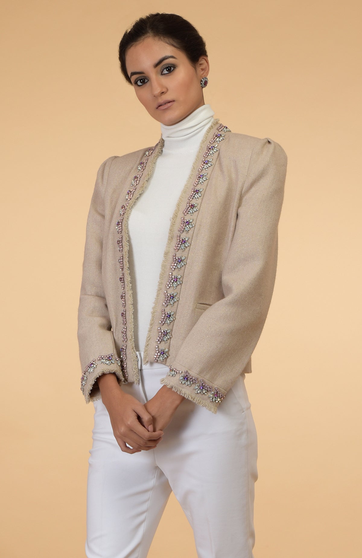 Beige cropped tweed jacket with long sleeves and purple, pink, silver crystal embroidery.