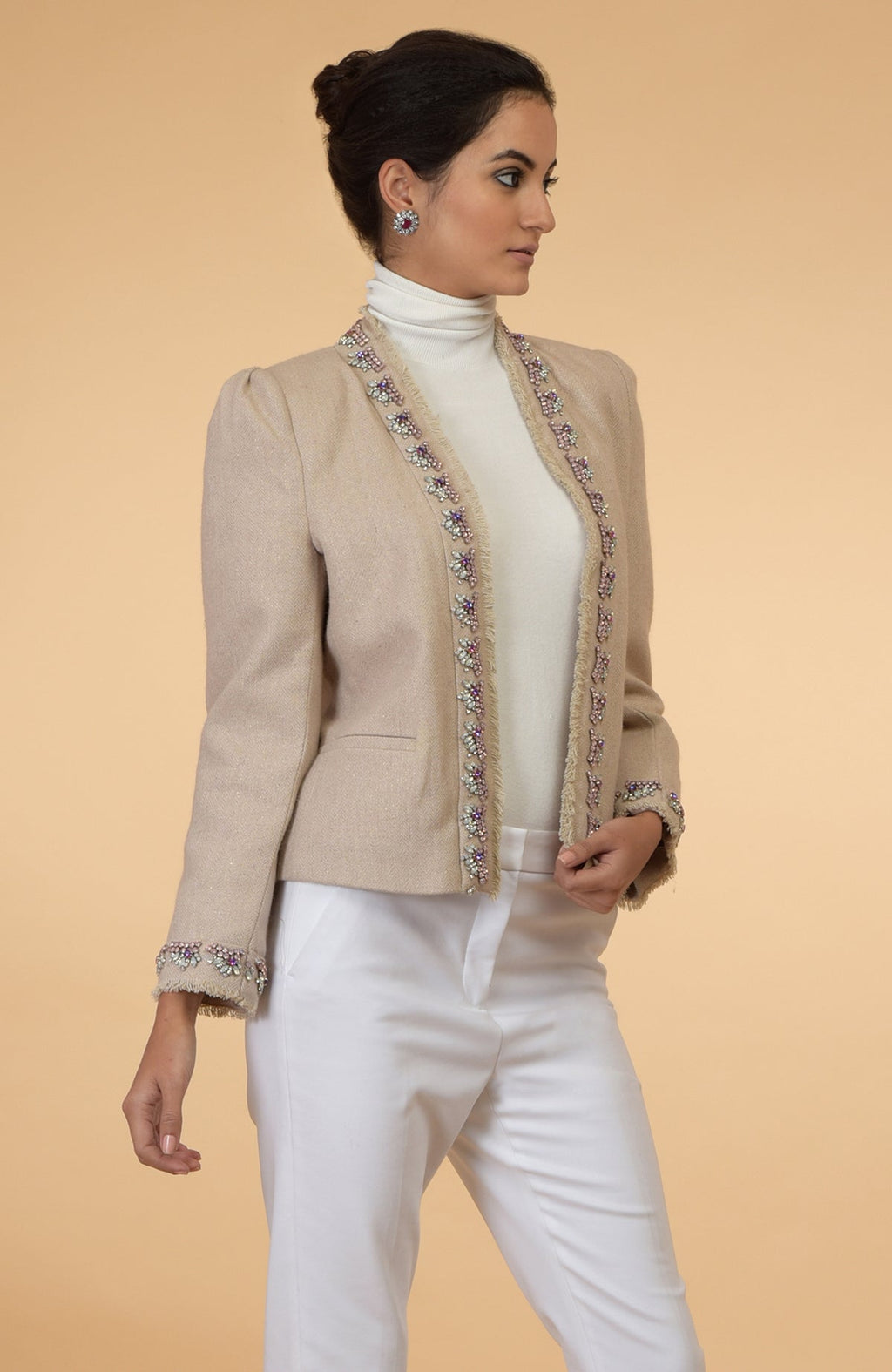 Beige cropped tweed jacket with long sleeves and hand embroidered purple, pink, and silver crystals