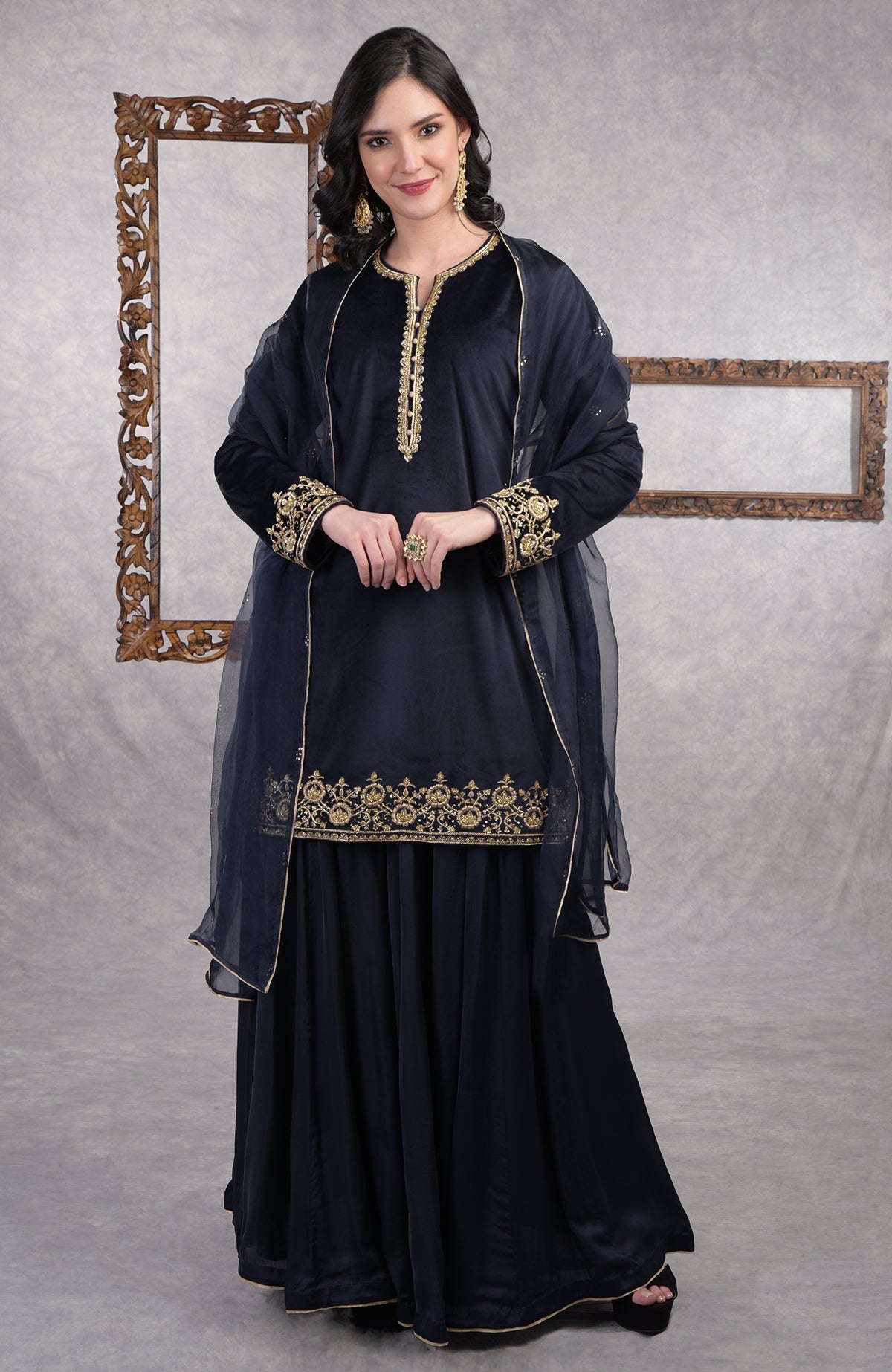 Midnight blue velvet sharara set with gold zardozi embroidery and floral organza dupatta.