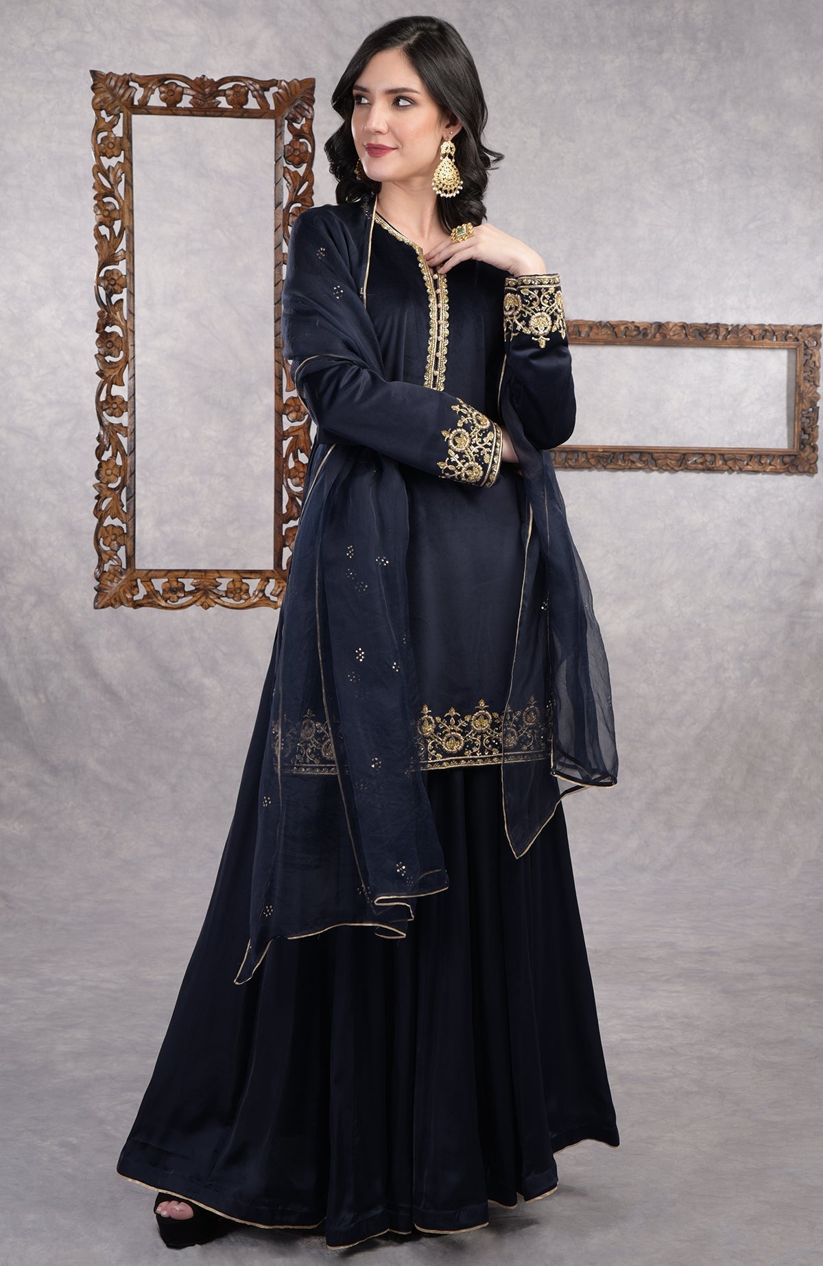 Midnight blue velvet sharara set with gold zardozi embroidery and floral organza dupatta.