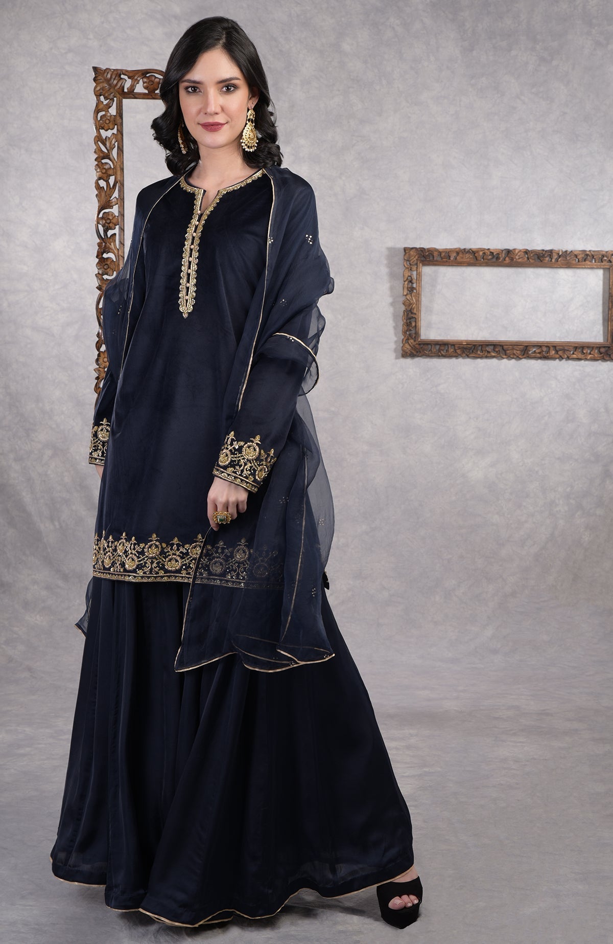 Midnight blue velvet sharara set with gold zardozi embroidery and floral organza dupatta.