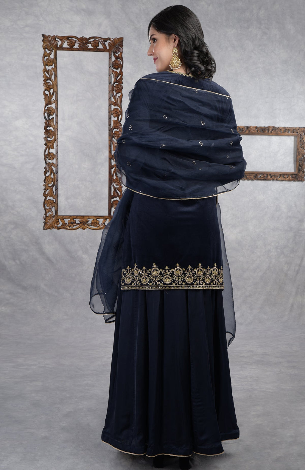 Midnight blue velvet sharara set with gold zardozi embroidery and floral organza dupatta.
