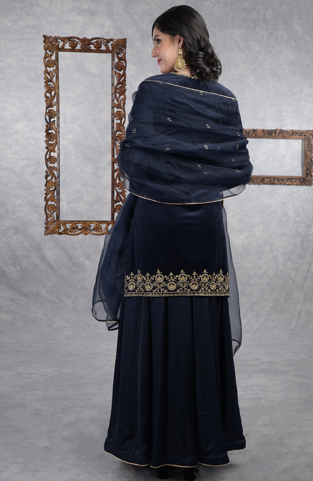Midnight blue velvet sharara set with gold zardozi embroidery and floral organza dupatta.