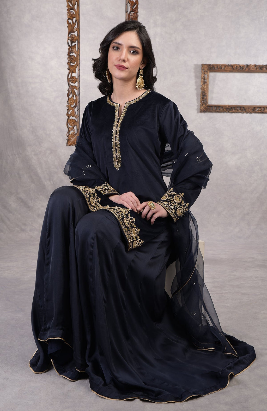 Midnight blue velvet sharara set with gold zardozi embroidery and floral organza dupatta.