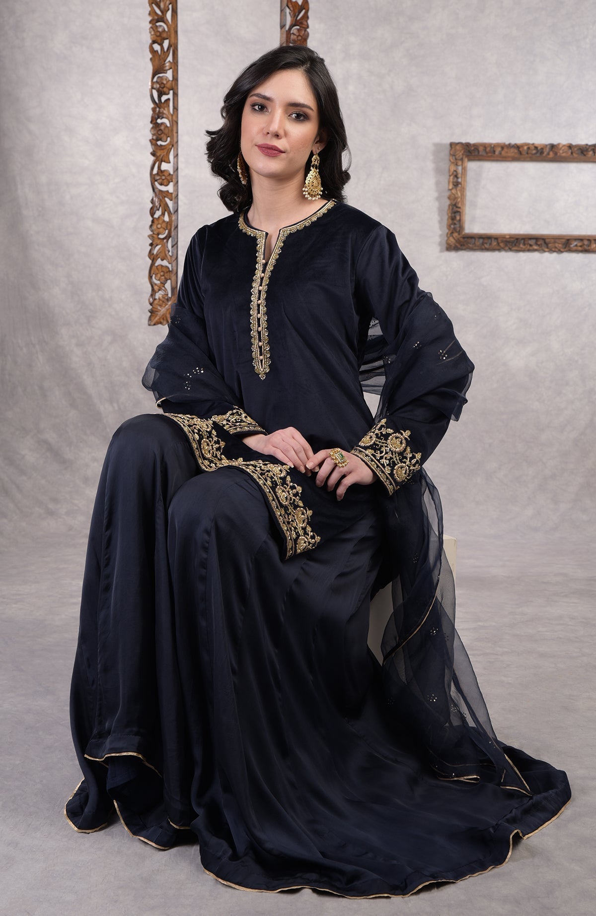Midnight blue velvet sharara set with gold zardozi embroidery and floral organza dupatta.