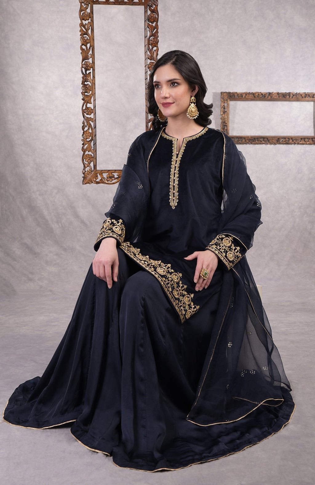 Midnight blue velvet sharara set with gold zardozi embroidery and floral organza dupatta.