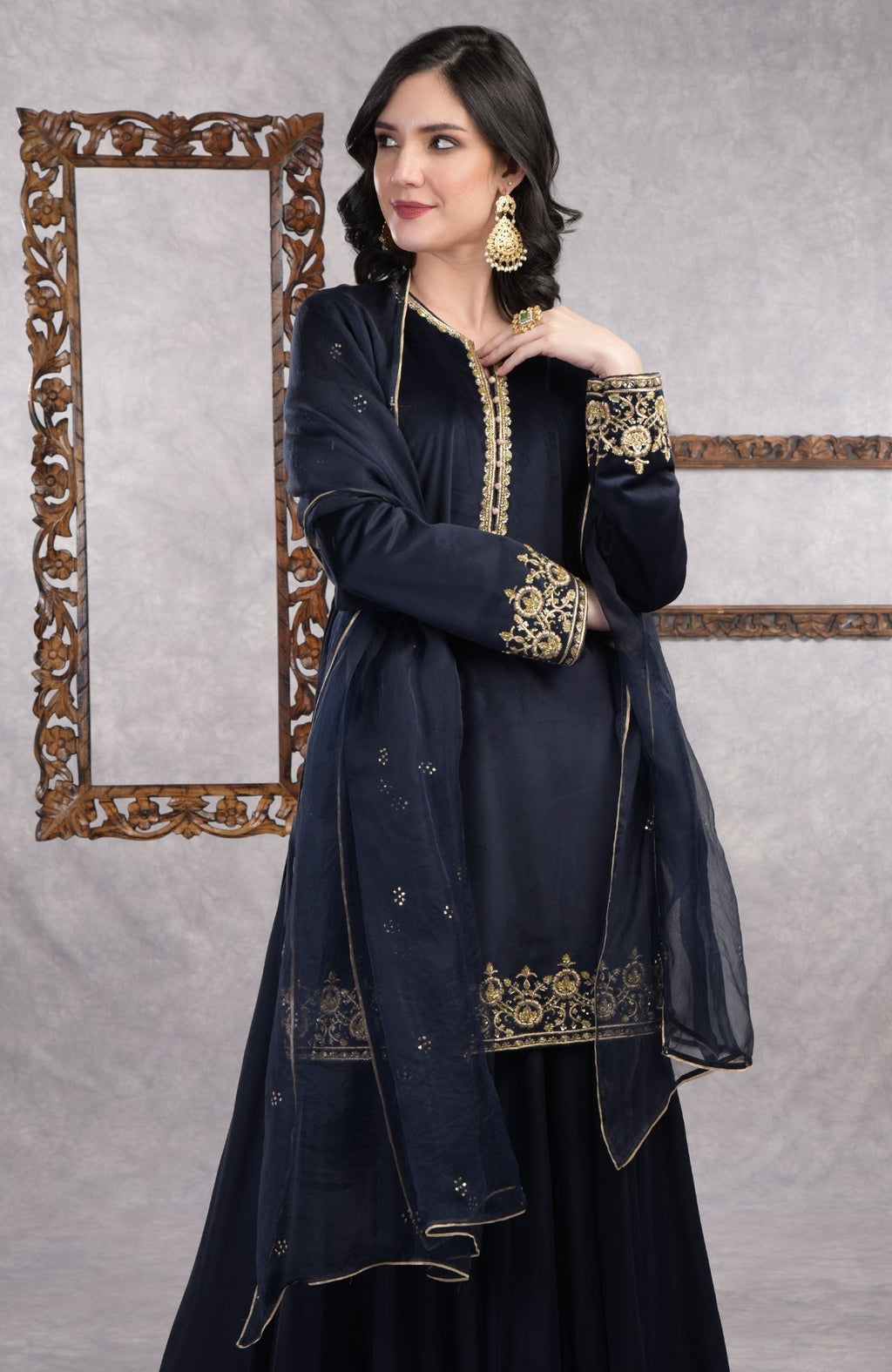Midnight blue velvet sharara set with gold zardozi embroidery and floral organza dupatta.