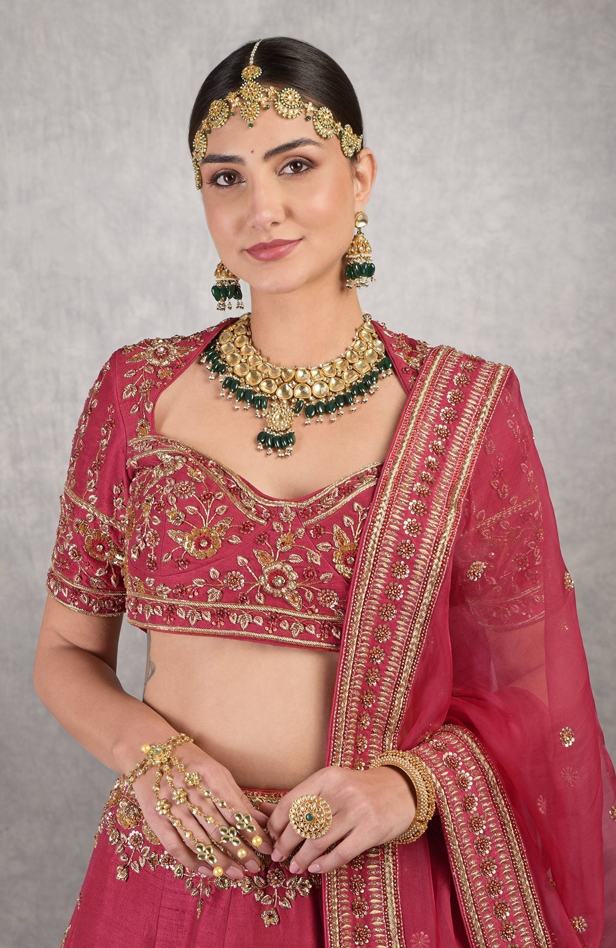 Red raw silk blouse with gold zardozi hand embroidery and floral motifs on sleeves