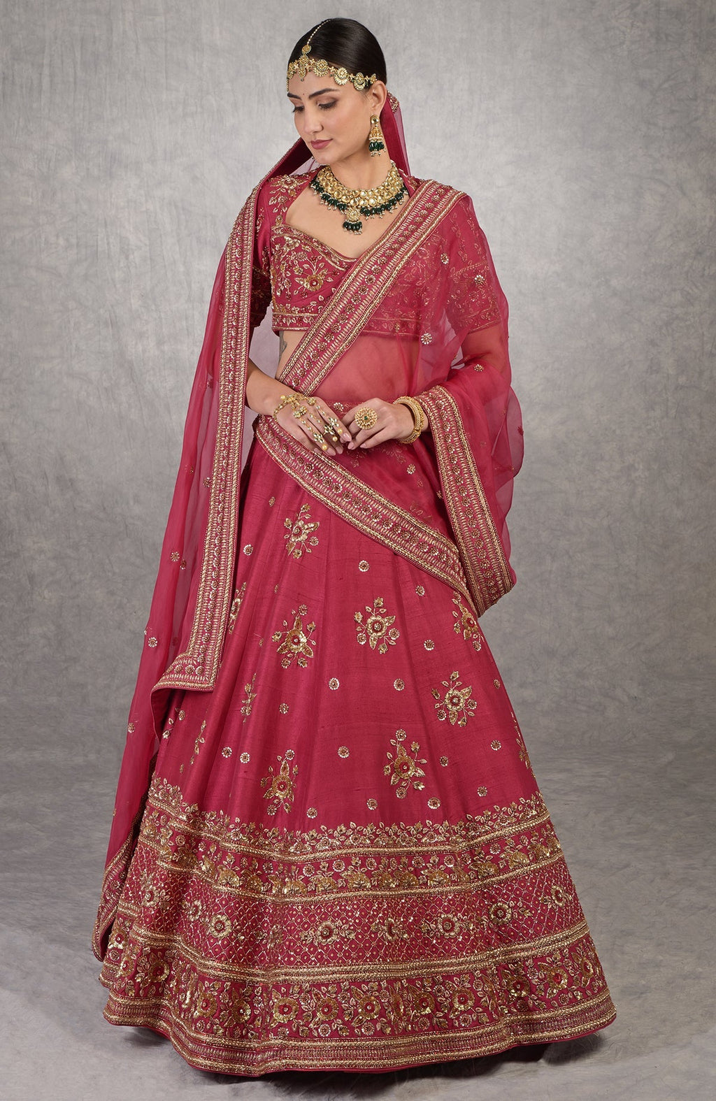 Red raw silk lehenga set with gold zardozi floral embroidery and matching blouse and dupatta.