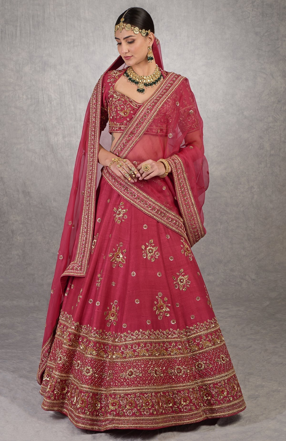 Red raw silk lehenga set with gold zardozi floral embroidery and matching blouse and dupatta.