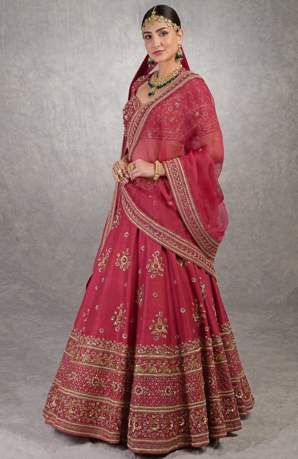 Deep red raw silk lehenga set with gold zardozi floral embroidery and matching blouse and dupatta.