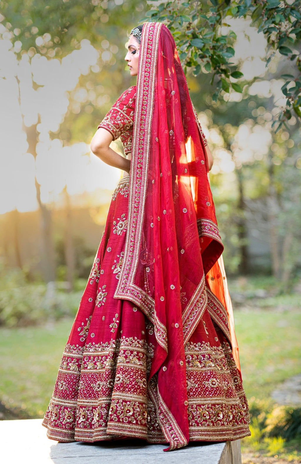 Deep red lehenga set with gold zardozi floral embroidery on blouse, skirt, and dupatta.