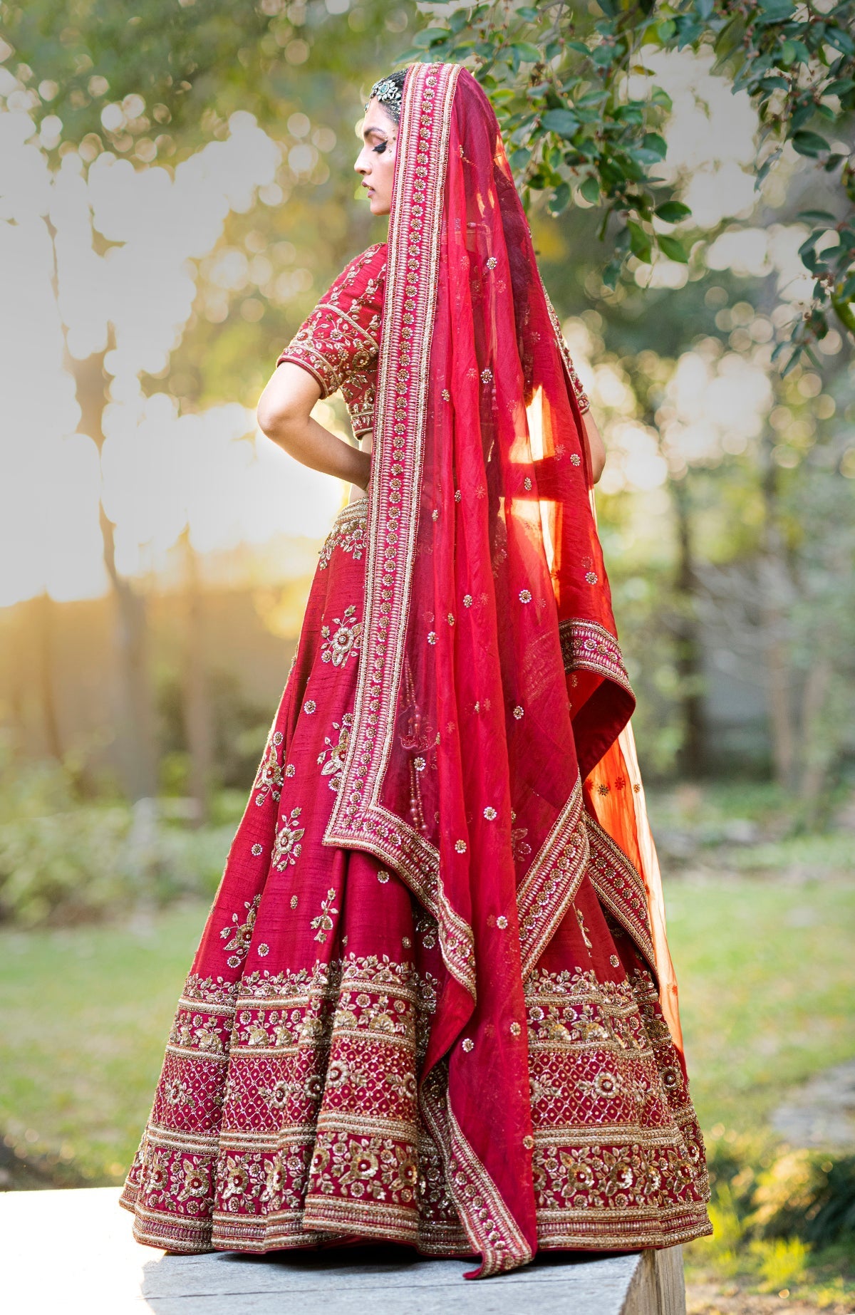 Deep red lehenga set with gold zardozi floral embroidery on blouse, skirt, and dupatta.