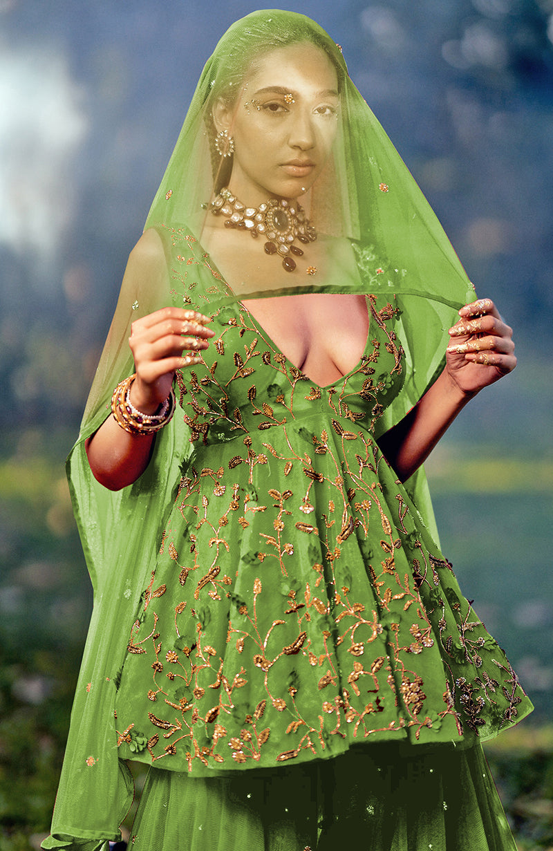 A woman models a green sharara set with gold floral embroidery and a sheer veil.