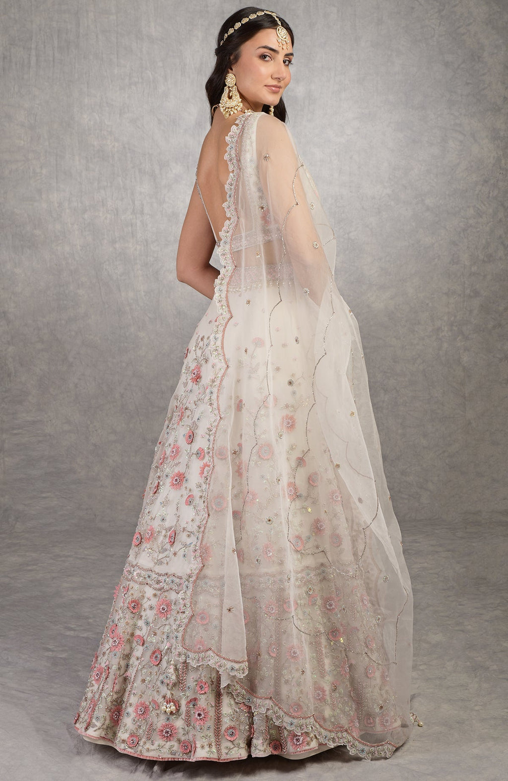 Off-white lehenga set with 3-D pink floral embroidery and crystal bead embellishments.